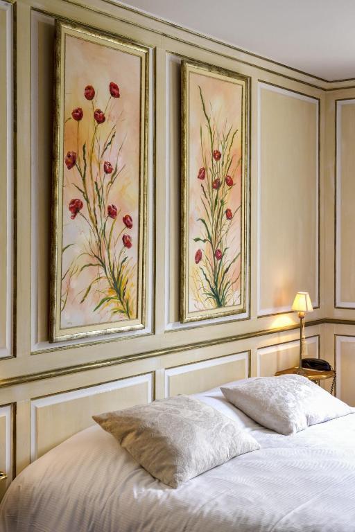 a bedroom with two pictures on the wall above a bed at Hotel Villa Catarie in Guéthary