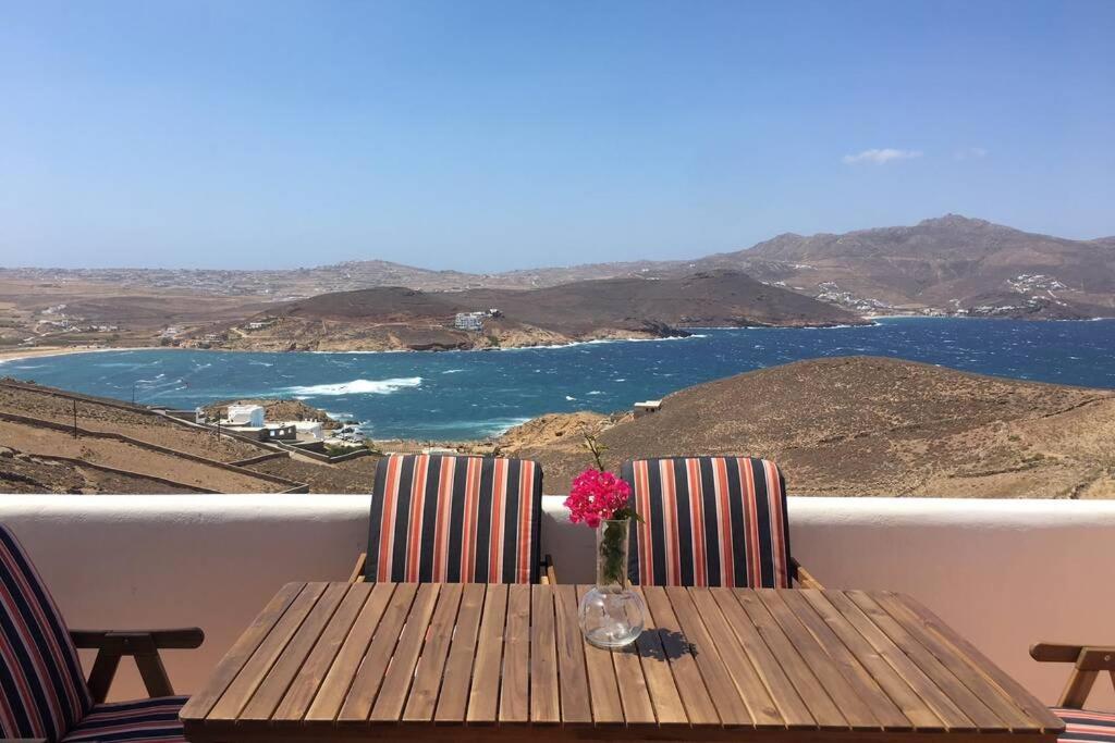 un tavolo di legno con un vaso con un fiore sopra di Ftelia Panoramic Sea View Villa Aias a Ftelia