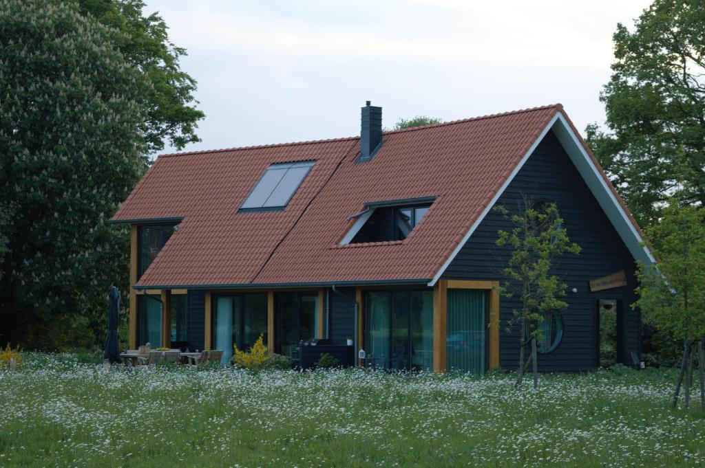 una casa con techo rojo en un campo en Erve Grootenhuys, en Deurningen