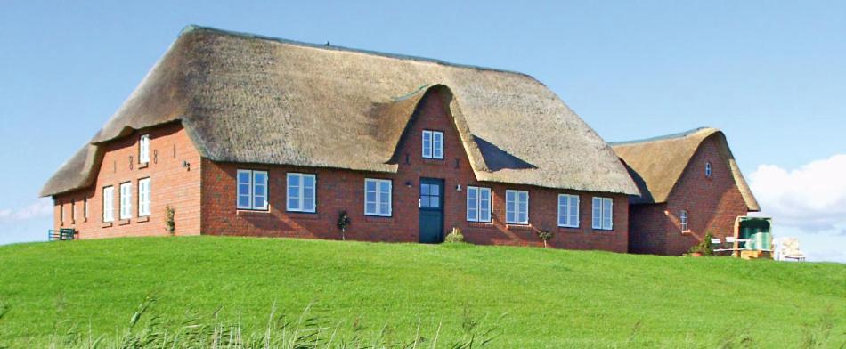 une grande maison en briques au sommet d'une colline herbeuse dans l'établissement Paulas Haus, à Pellworm