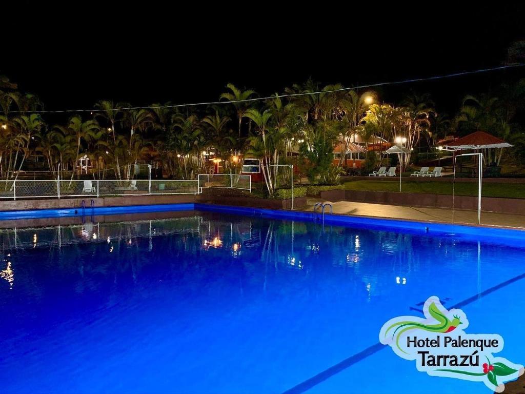 a large blue swimming pool at night at Hotel Palenque Tarrazu in San Marcos