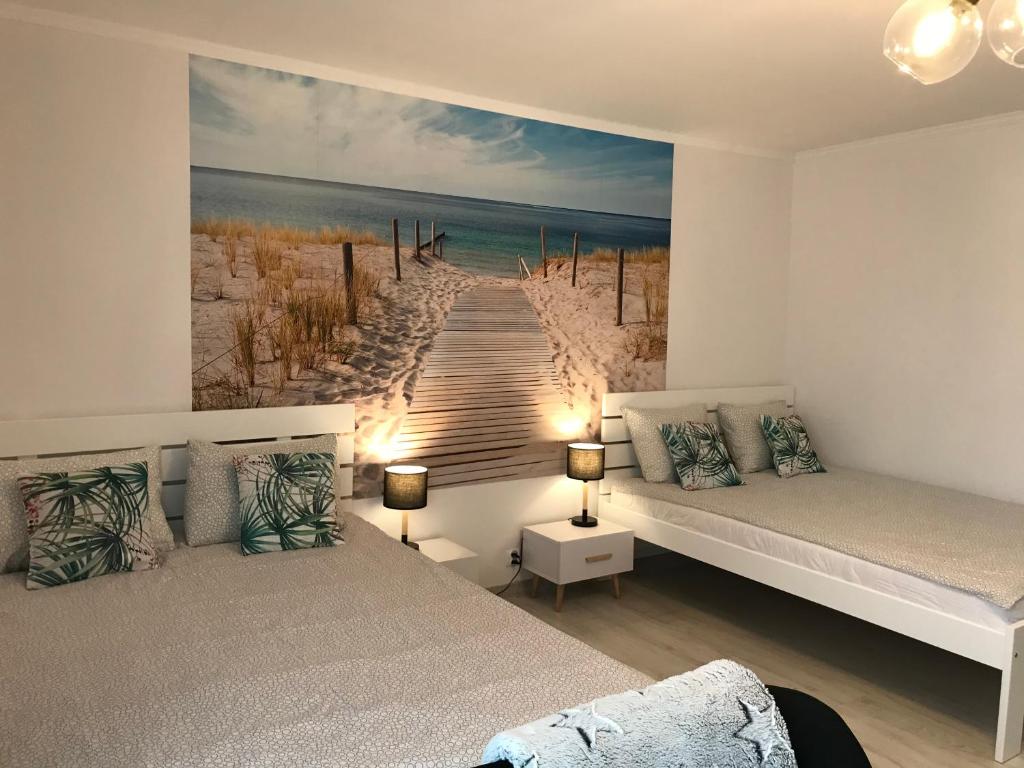 a bedroom with two beds and a painting of a pier at Danusia in Władysławowo