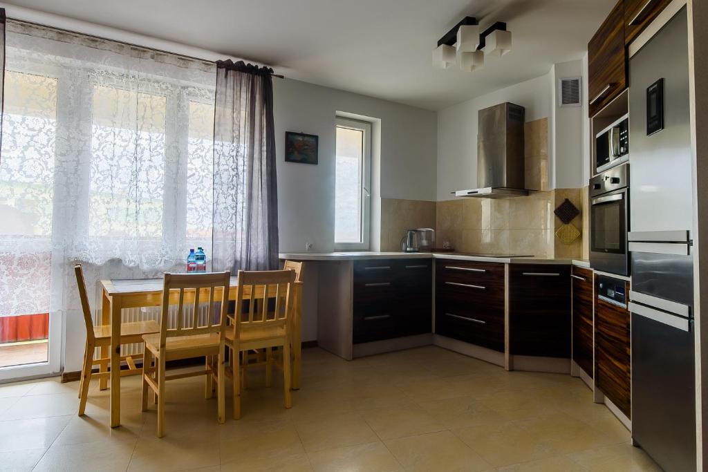 a kitchen with a table and chairs and a dining room at Apartament 25 in Pisz
