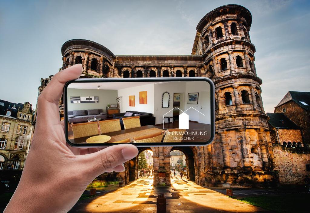 una persona tomando una foto de un edificio antiguo en Ferienwohnung Reuscher, Trier-Newel, en Newel