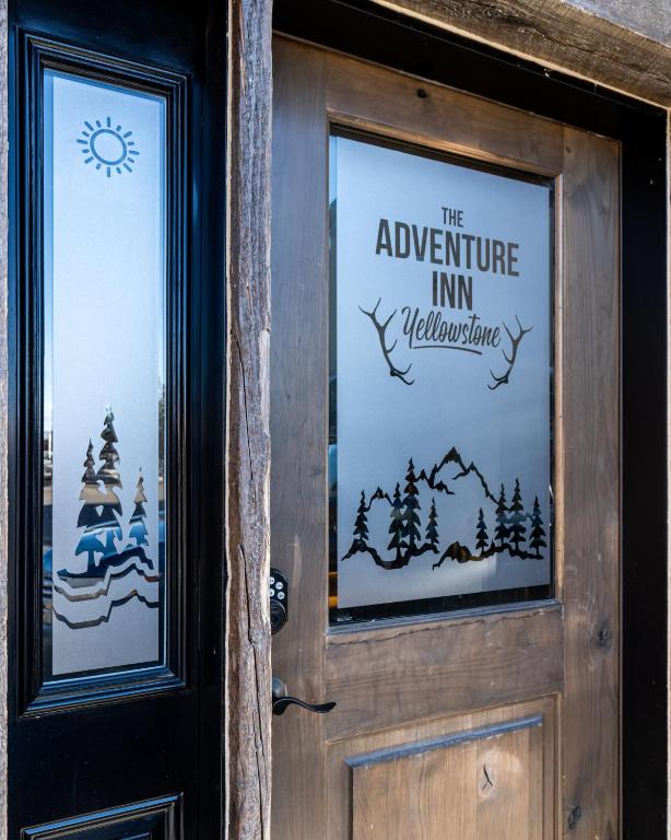 a door with the adventure inn welcomes sign on it at The Adventure Inn Yellowstone- Jack Creek: 2 Queen Suite 1min from Yellowstone, sleeps 4. in West Yellowstone