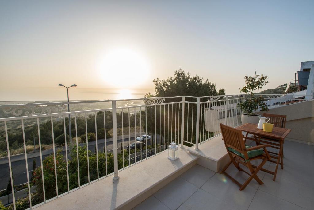 Un balcón con una mesa y vista a una calle. en Eshkol Housing Haifa - Luxury Villa Panoramic Sea View חיפה כרמל, en Haifa
