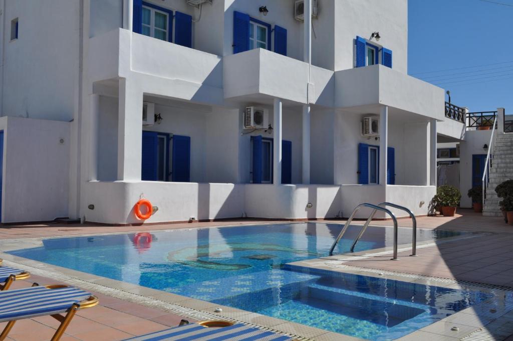 a swimming pool in front of a building at Cyclades Hotel in Karterados