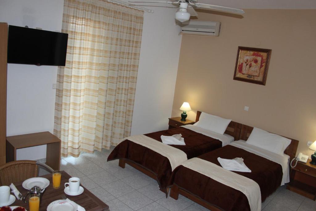 a hotel room with two beds and a table at 123 Armonia Studios in Loutra Edipsou