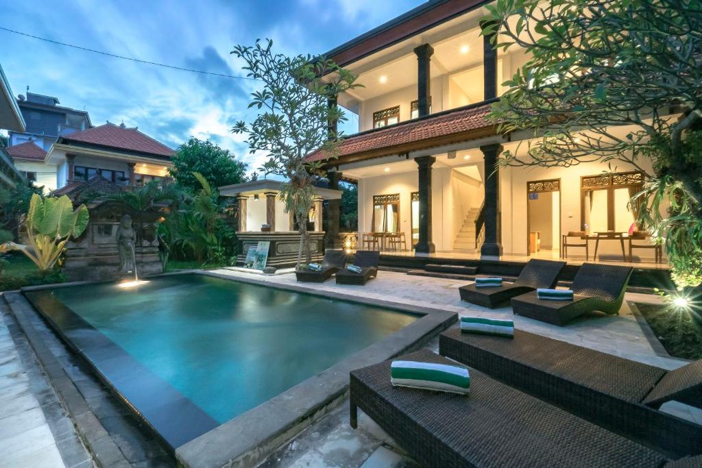 a house with a swimming pool in front of a house at Esty House in Ubud