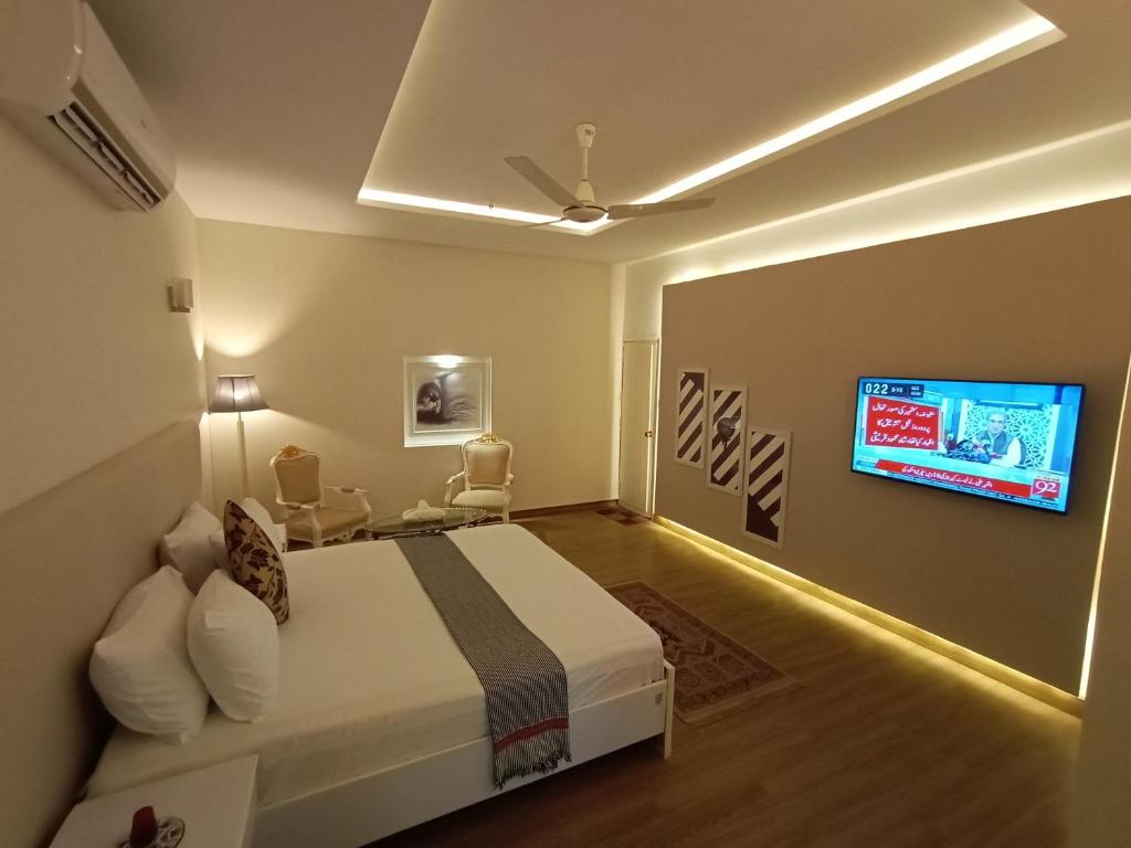 Schlafzimmer mit einem Bett und einem Flachbild-TV in der Unterkunft Hilton Bayview lnn in Karatschi