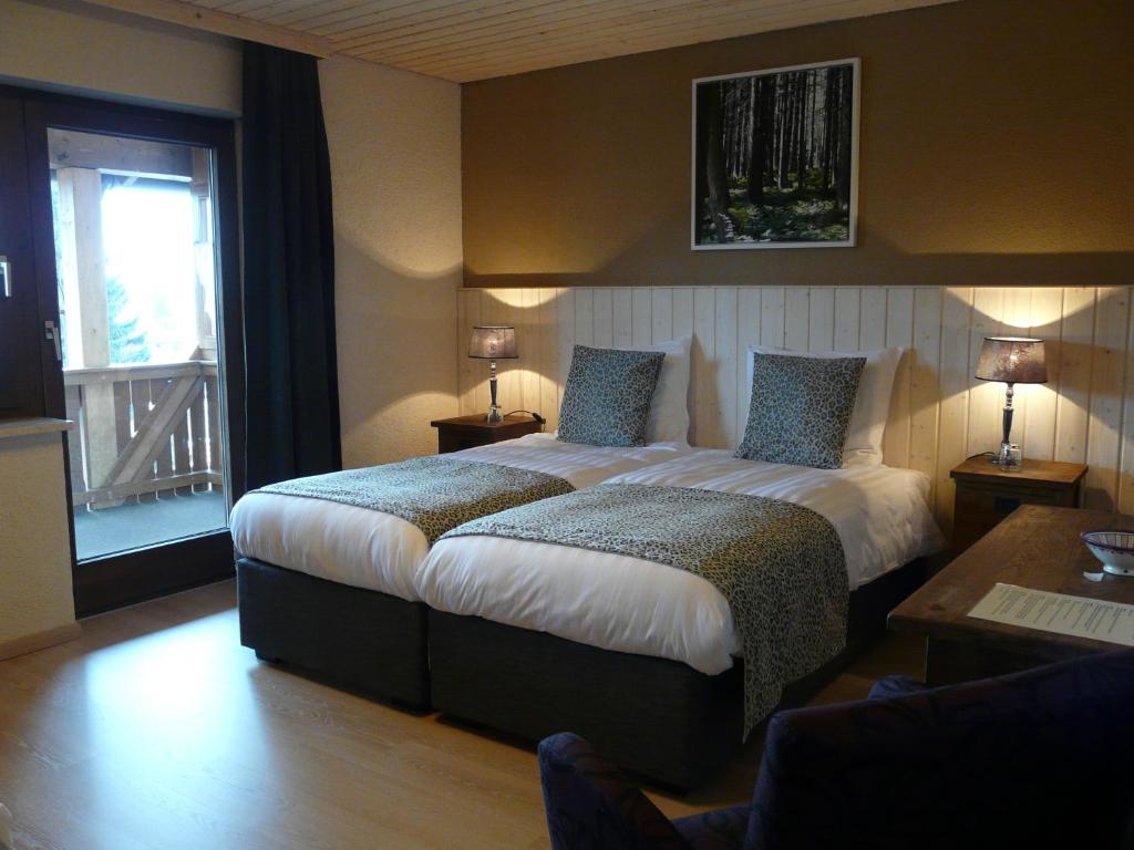 a hotel room with a large bed and a window at Landhaus Meine Auszeit in Bodenmais