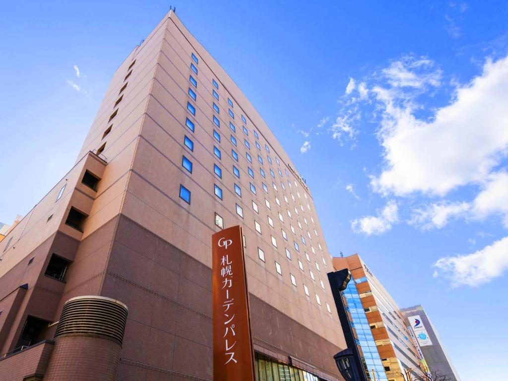 ein hohes Gebäude mit einem Schild davor in der Unterkunft Hotel Sapporo Garden Palace in Sapporo