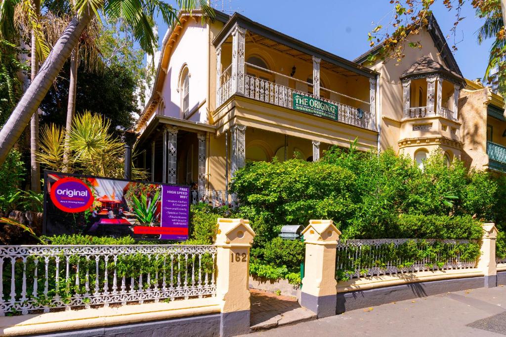 a large house with a fence in front of it at Original Backpackers in Sydney