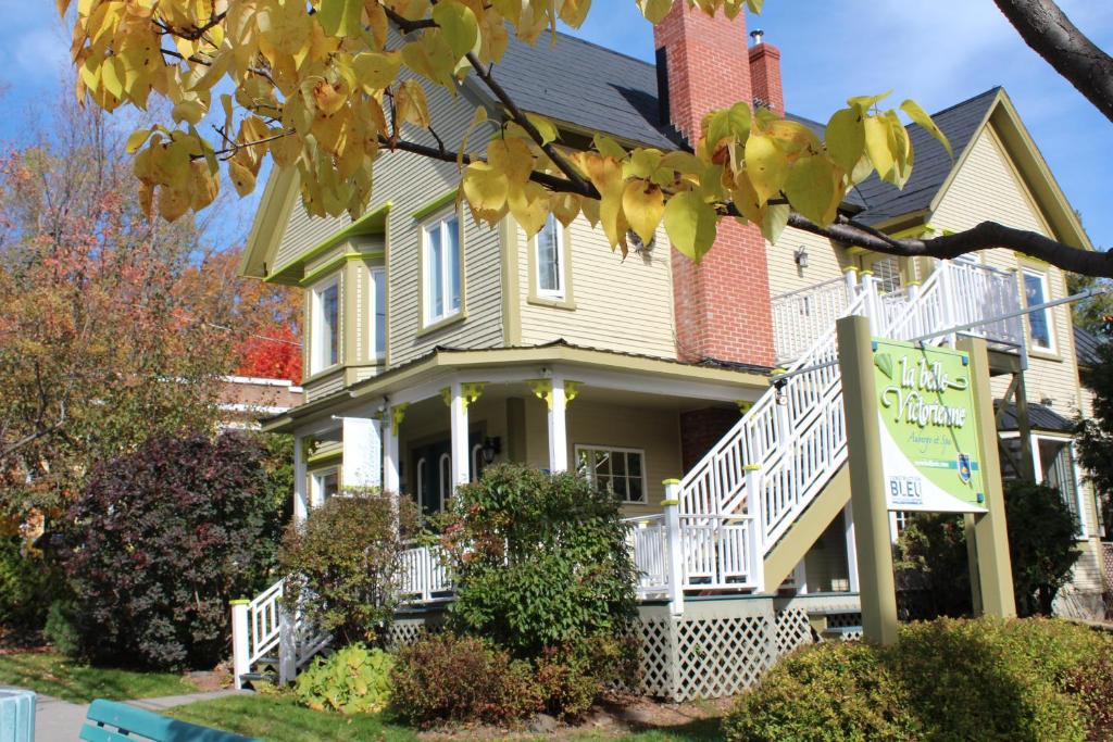 una casa con un cartel delante de ella en La Belle Victorienne, en Magog-Orford