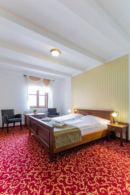Postel nebo postele na pokoji v ubytování Hotel U Zlatého kohouta