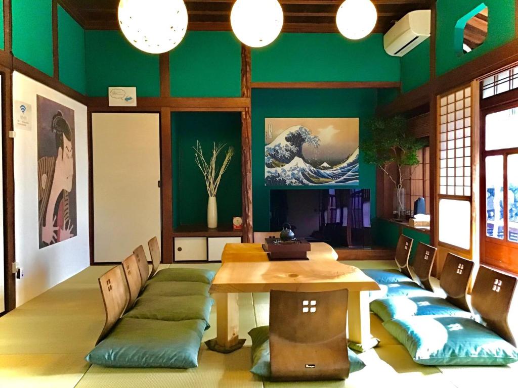 a dining room with green walls and a table and chairs at HACDAI / Vacation STAY 55047 in Beppu