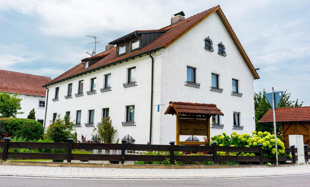 ein großes weißes Gebäude mit braunem Dach in der Unterkunft Gäste- und Appartementhaus Roswitha Huber in Würding