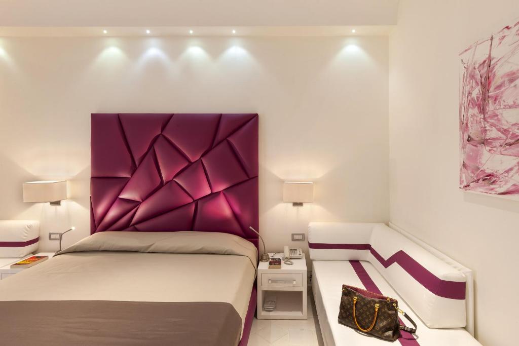 a bedroom with a bed with a purple headboard at Palazzo Montefusco in Sorrento