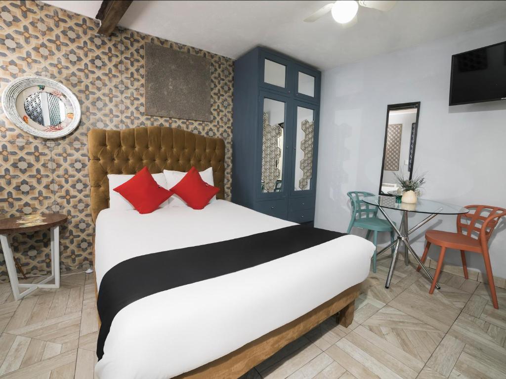 una camera da letto con un letto con cuscini rossi e un tavolo di Coyotito Beds Coyoacan, suites a tu alcance!!! a Città del Messico