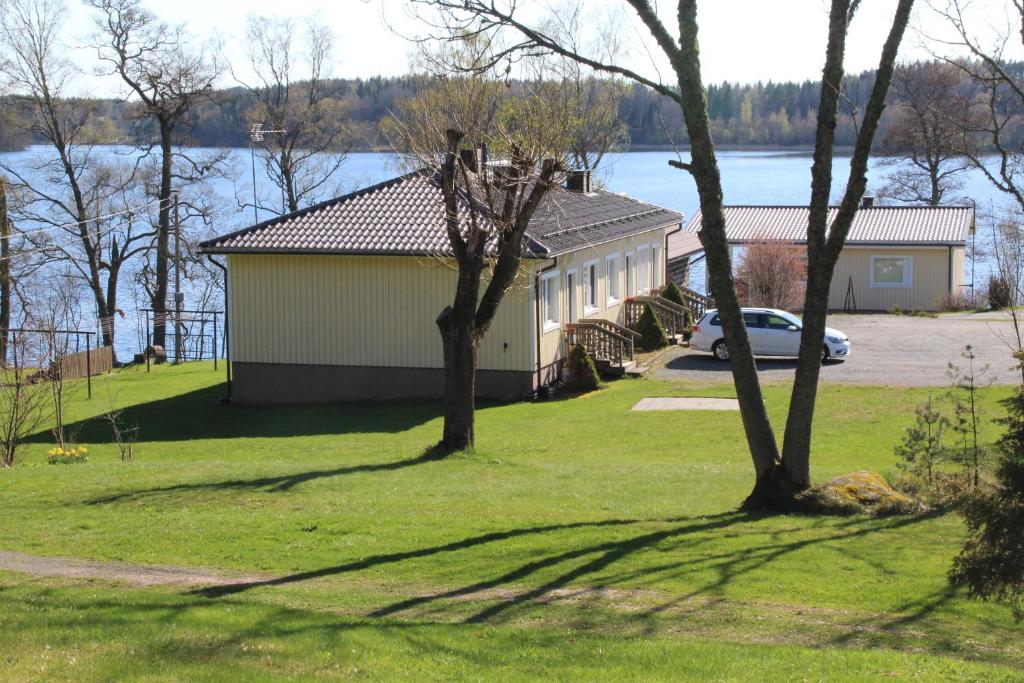 un bâtiment avec une voiture garée dans un champ arboré dans l'établissement Labbnäs Semesterhem, Radhuset, à Kemiönsaari