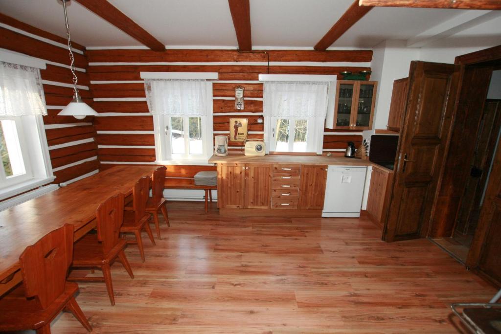 una cocina con una mesa de madera larga y sillas en Penzion Semerink, en Janov nad Nisou
