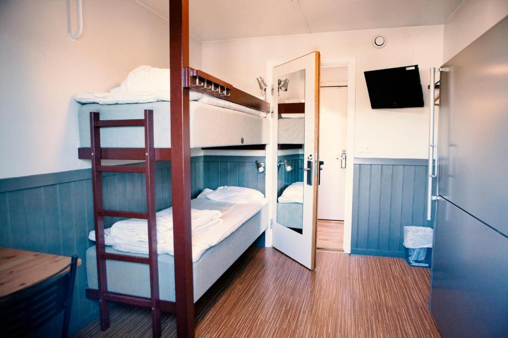 a bunk bed room with two bunk beds and a mirror at Lisebergsbyns Vandrarhem in Gothenburg