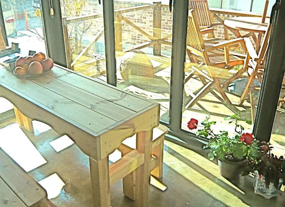 a wooden table sitting on top of a porch at Guesthouse in Picture in Jeonju
