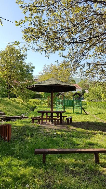 a picnic table with an umbrella in a park at Apartmani Smiljanic app 3 in Soko Banja