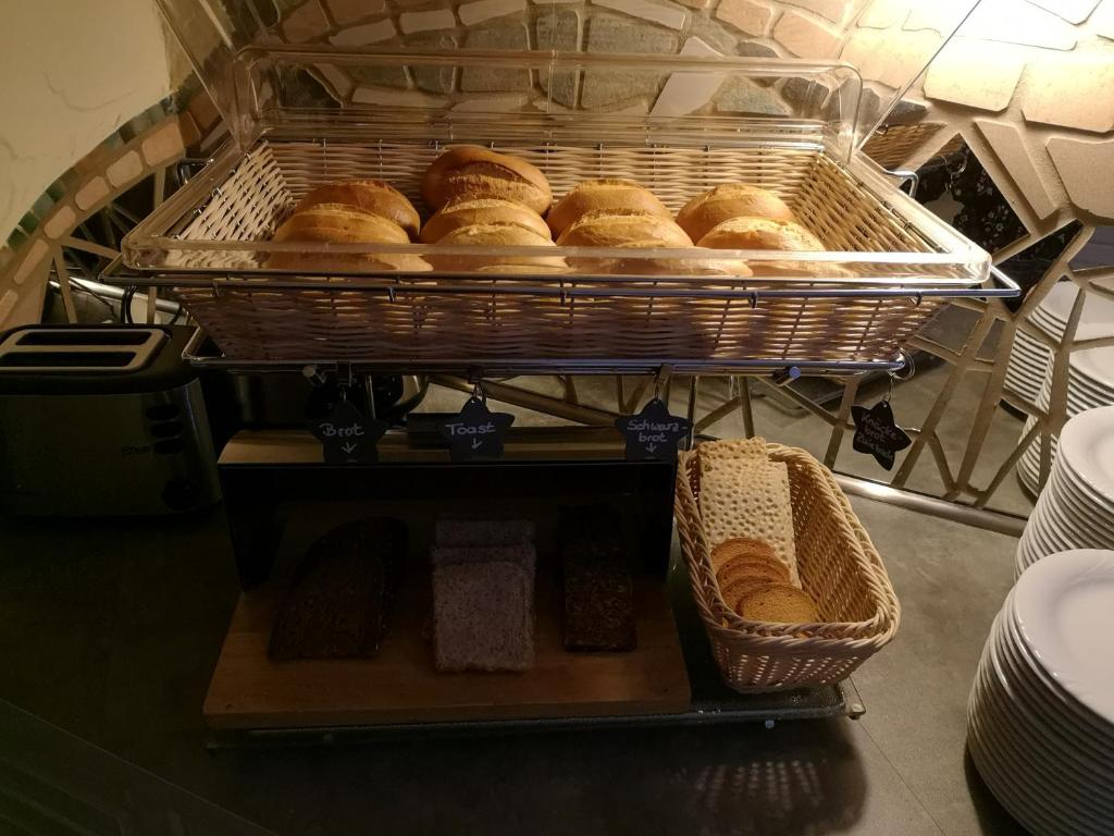a bunch of breads in a basket on a shelf at Hotel Köln-Bonn in Bornheim
