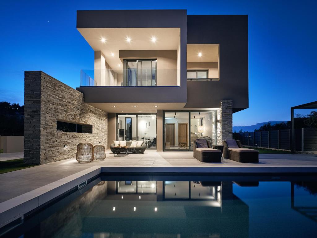 a modern house with a swimming pool at night at Aguacate Meliti in Tsilivi