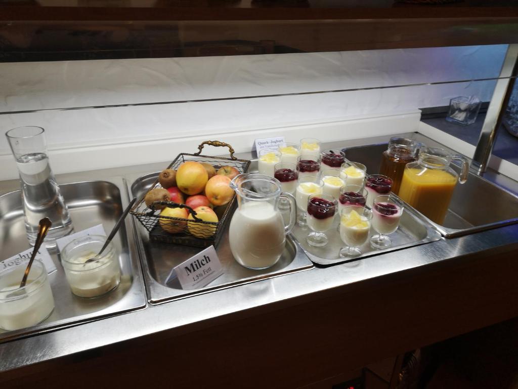 a tray of food with milk and fruit and drinks at Hotel Köln-Bonn in Bornheim