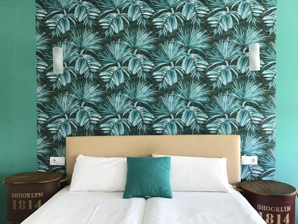 a bedroom with a bed with a blue and white wallpaper at Hotel Nómadas in Vejer de la Frontera