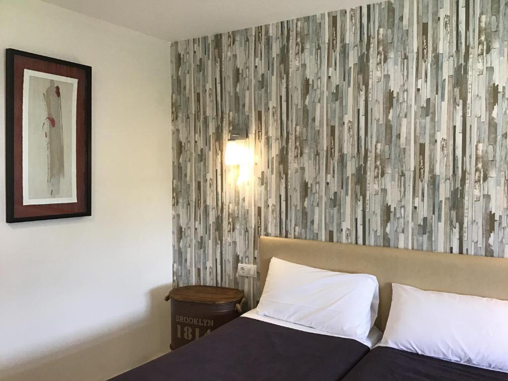 a bedroom with a bed and a wall with a picture at Hotel Nómadas in Vejer de la Frontera