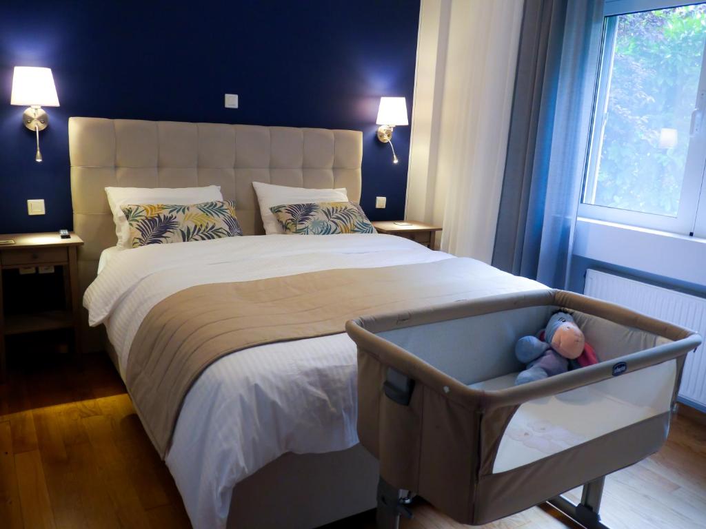 a bedroom with a large bed with a crib at Garden Apartment next to the Mall -Private Parking in Athens