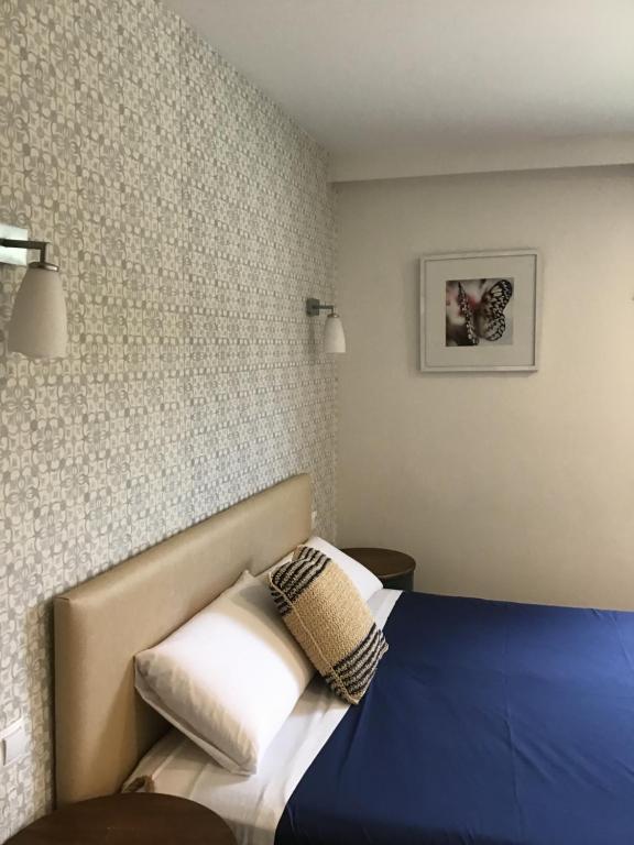 a hotel room with a bed with a blue blanket and pillows at Hotel Nómadas in Vejer de la Frontera