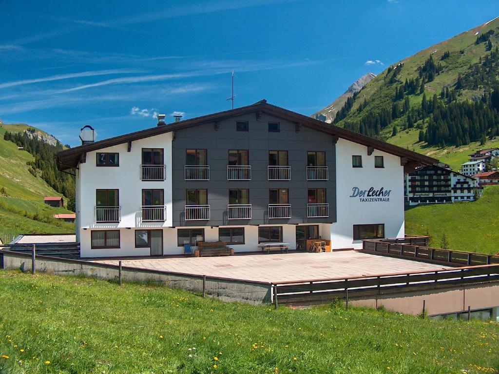 ein großes weißes Gebäude mit einer Rampe auf einem Feld in der Unterkunft Der Lecher in Lech am Arlberg