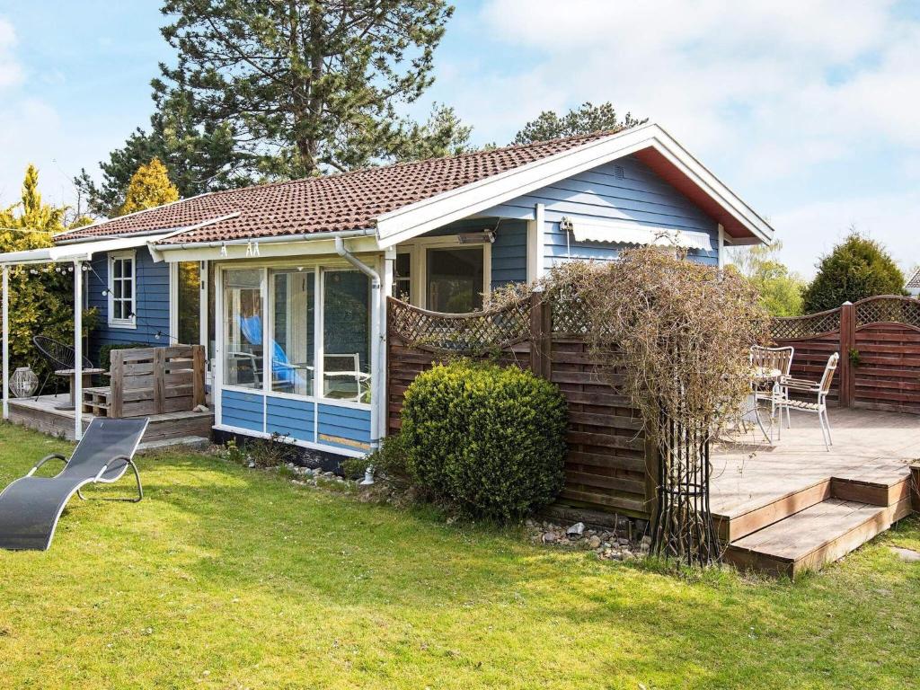 een blauw huisje met een terras en een patio bij 6 person holiday home in Slagelse in Slagelse