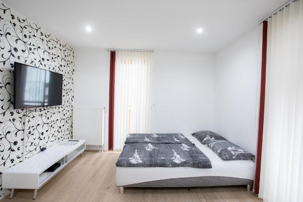1 dormitorio con 1 cama y TV en la pared en Apartment Arnika Kranjska Gora, en Kranjska Gora