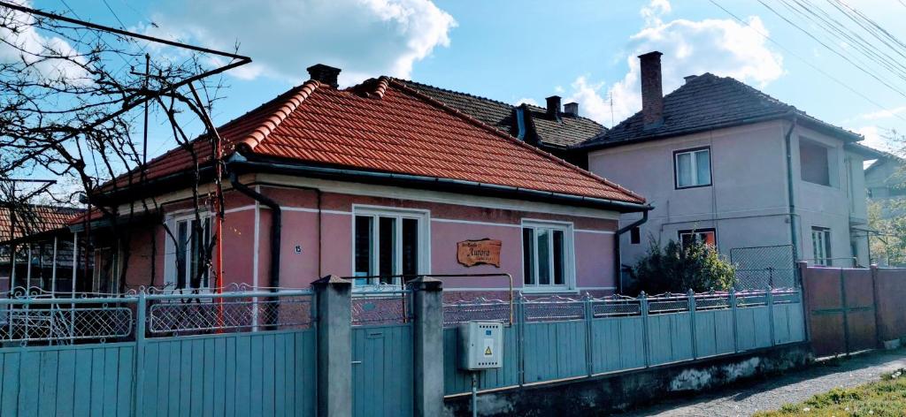 una casa con una valla delante de ella en Aurora vendégház, en Sfântu-Gheorghe