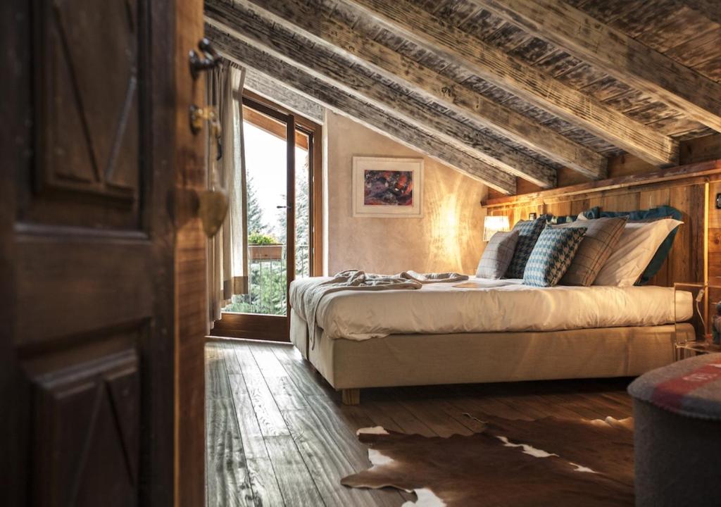 ein Schlafzimmer mit einem Bett und einem großen Fenster in der Unterkunft Le Parfum du Sel in Aosta