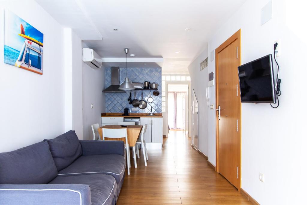 ein Wohnzimmer mit einem Sofa und einer Küche in der Unterkunft Apartamento con terraza cerca de la playa in Valencia