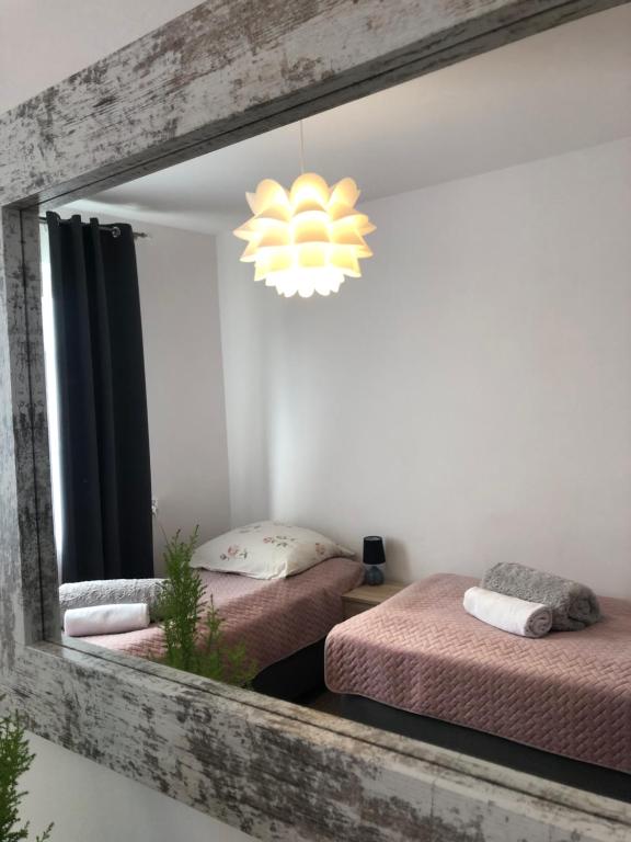 a mirror in a room with two beds and a chandelier at Apartament u Gogoca in Tylicz