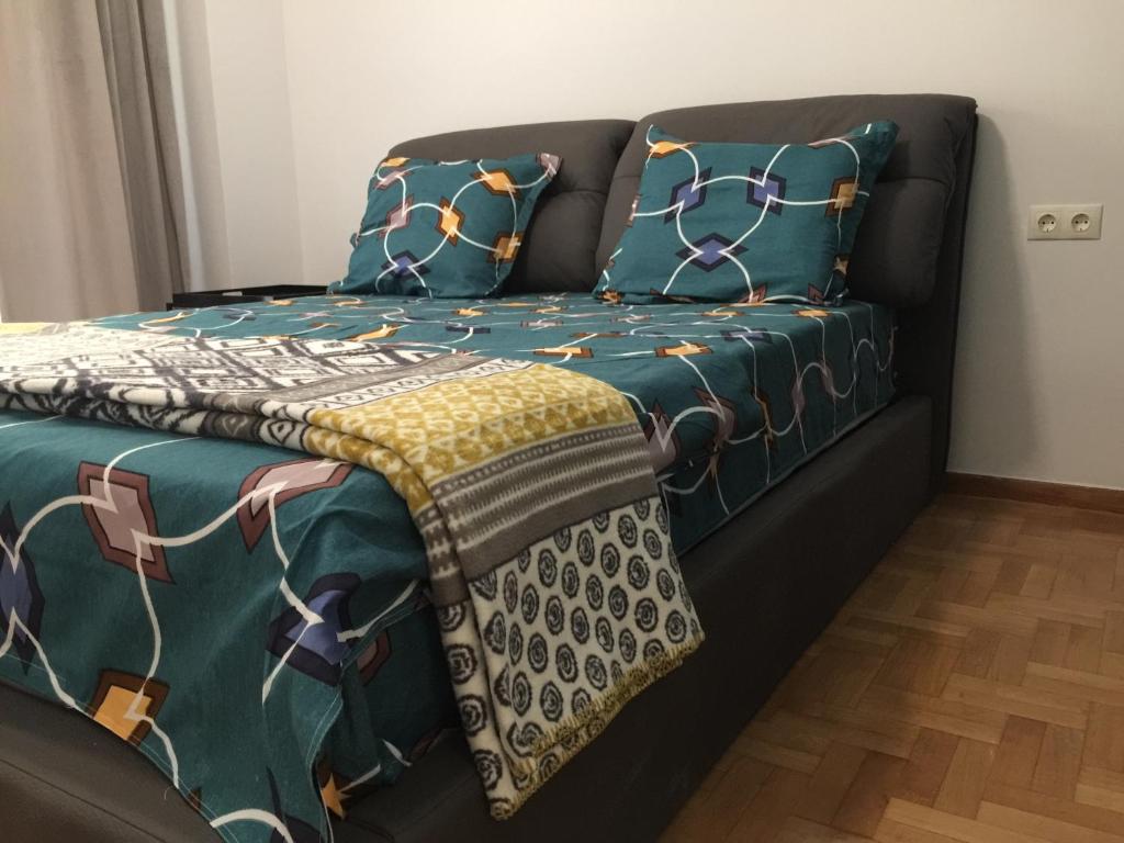 un divano con coperte verdi e cuscini sopra di Patision Avenue, Apartment with Two bedrooms ad Atene