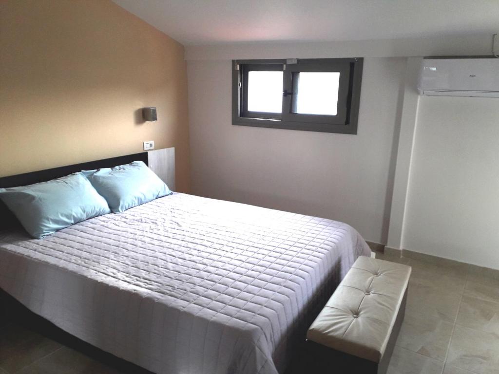 a bedroom with a large white bed with a window at InStyle Zakynthos town Apartment in Zakynthos