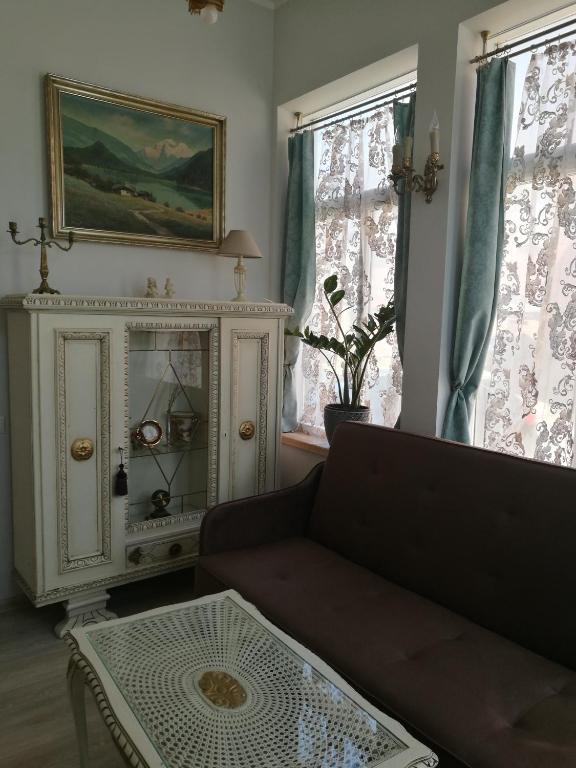 een woonkamer met een bank en een tafel bij Golden Amber Apartment in Liepāja