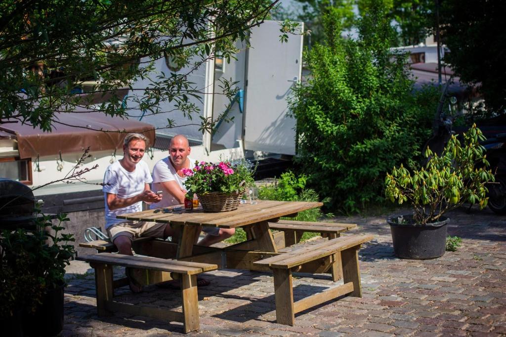 two people sitting at a picnic table with flowers at Nachtwacht Apartment in Amsterdam