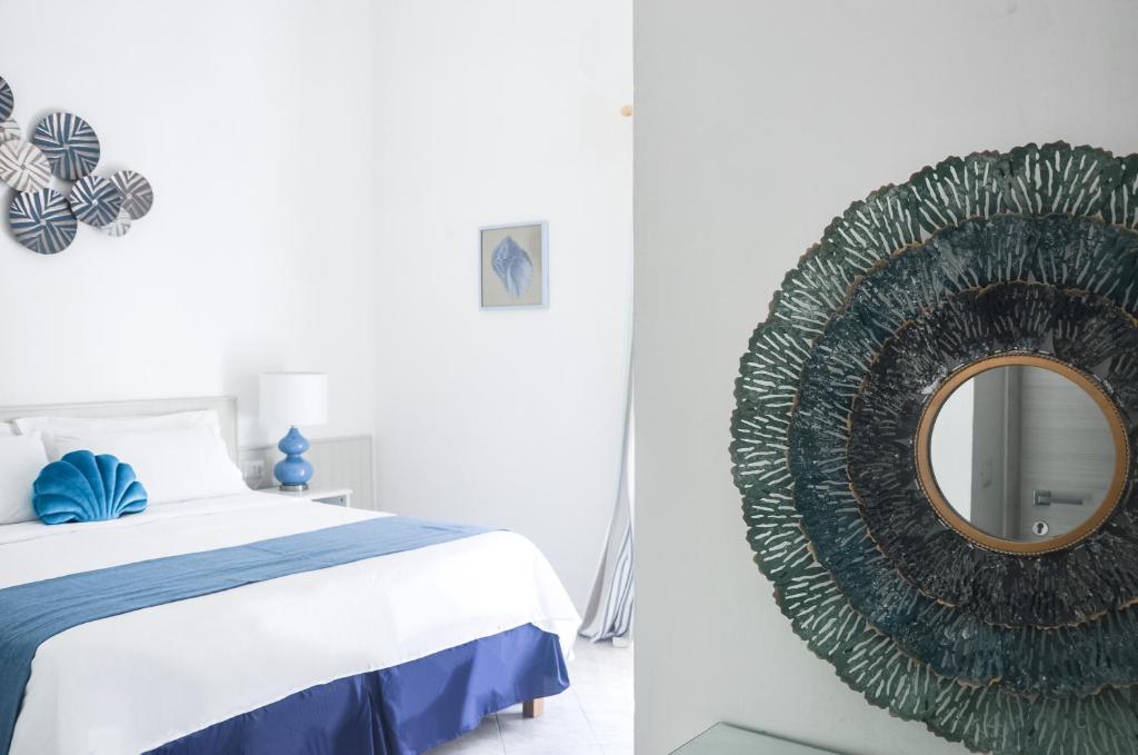 una camera da letto con un grande specchio accanto a un letto di Hotel Guarracino a Capri