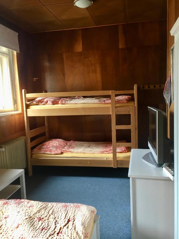 two bunk beds in a room with a television at Turistická Chata Pláně in Český Dub