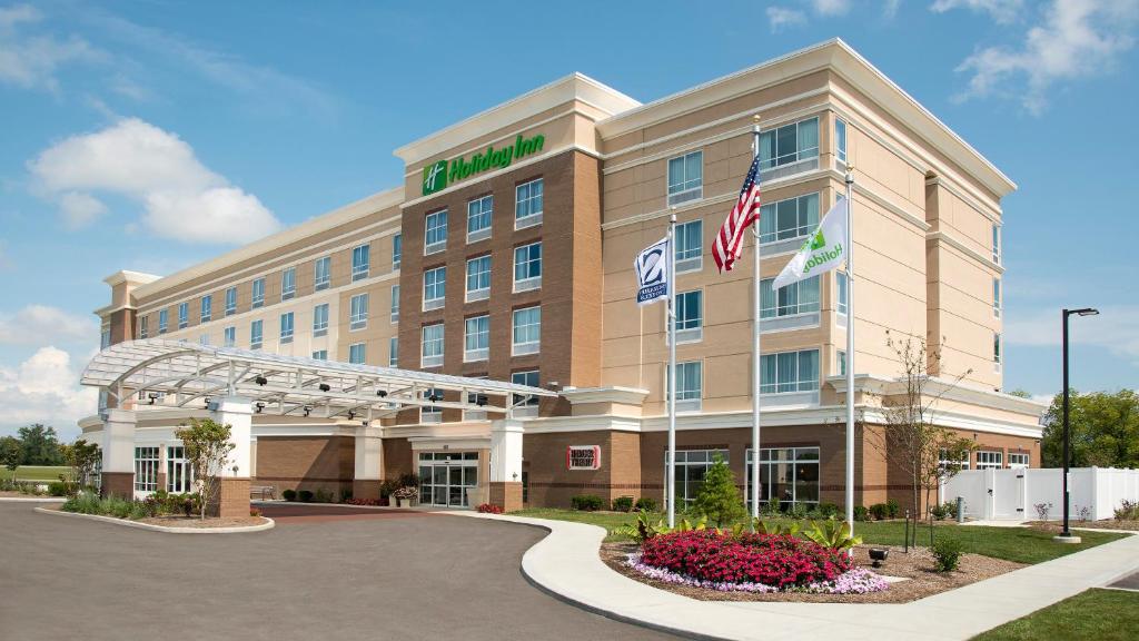 um edifício de hotel com bandeiras em frente em Holiday Inn Indianapolis Airport, an IHG Hotel em Indianápolis