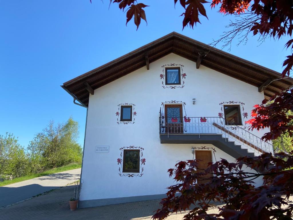 a white house with a balcony and stairs at Ferienhaus am Kagerstein in Neukirchen beim Heiligen Blut